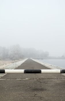 road to far away with barrier on freeze hoarfrosted landscape