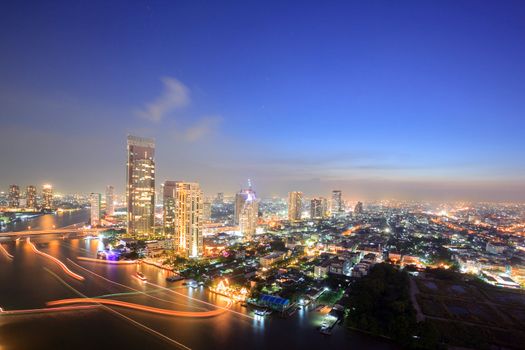 Aerial view of Bangkok Skyline along Chaophraya River at dusk with star trail