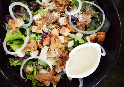 Salad with cream sauce in black dish