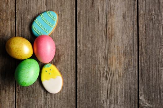 Easter homemade gingerbread cookie and eggs over wooden table