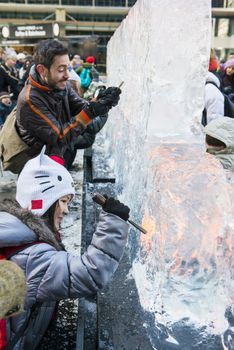 LONDON, UK - JANUARY 13: Public activity at the London Ice Sculpture Festival, in Canary Wharf. Visitors were invited to carve this block of ice. January 13, 2013 in London.