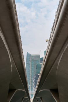 Skyscrapers and sky framed by modern concrete bridge
