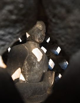 Buddha statue inside of a close stupa in Borobudur, or Barabudur, temple Jogjakarta, Java, Indonesia at sunrise. It is a 9th-century Mahayana temple and the biggest  Buddhist Temple in Indonesia.