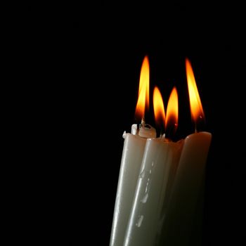 sacred candles in dark on black background
