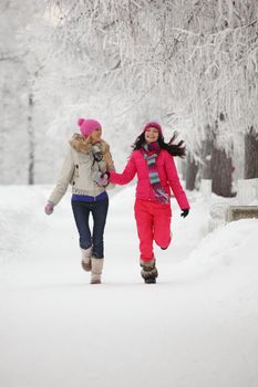 two winter women run by snow frosted alley