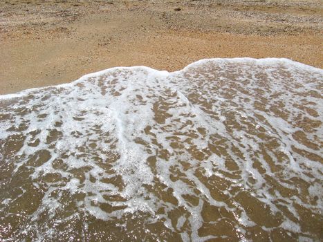 Marine waves on the sand of seacoast