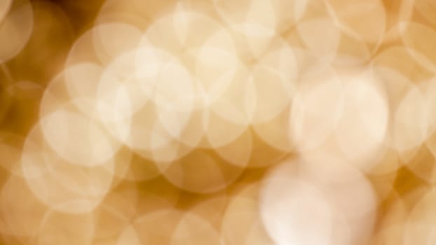Blurry Christmas background abstract with defocused golden lights and shadows.