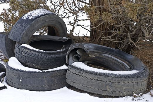 A pile of destroyed tires dumped on public lands, littering the landscape.