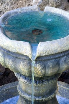 Vertical close up shot of coins in a small fountain/water feature.