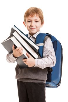 Little smiling child boy with school backpack holding education books in hands