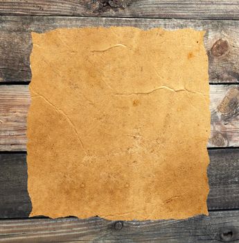 Empty grunge paper against wood background