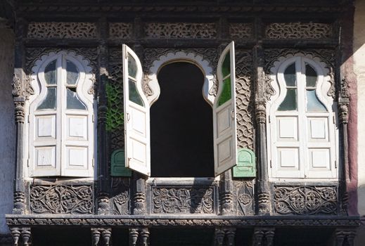 Three old windows with shutters and decorative stone ornaments. Rajasthan, India