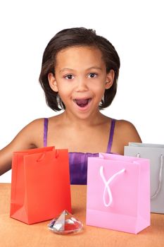 An exited young girl opens her gifts and finds a diamond.