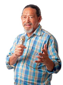 A senior male expresses musical notes whilst holding a microphone in his hand.