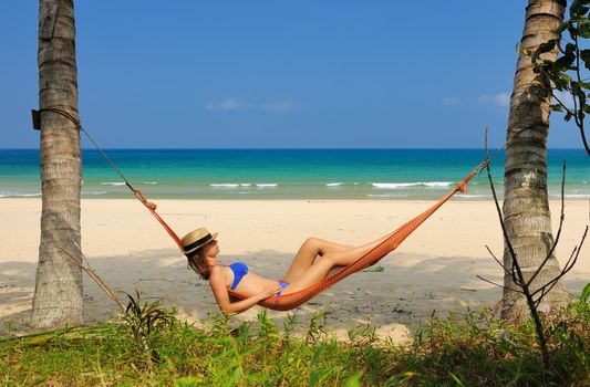 Woman in hammock on tropical beach at Tioman island, Malaysia