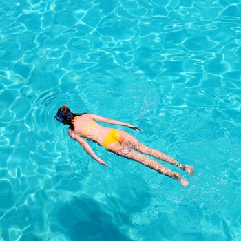 Woman snorkeling in crystal clear turquoise water at tropical beach