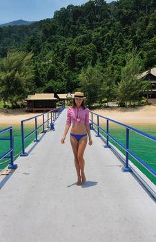 Woman at beach jetty wearing hat