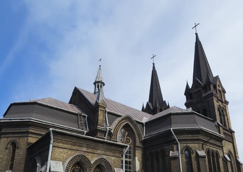 Rear side view of the upper part of the Catholic church in the summer sunlight.