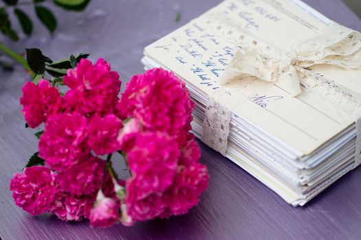 stack of old letters tied with lace ribbon with roses