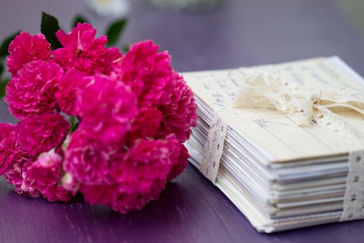 stack of old letters tied with lace ribbon with roses