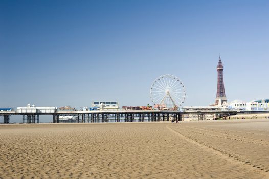 View across the sand of Blackpool Beach to the pier with the historic Blackpool Tower and pier in the background