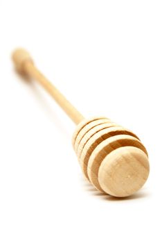 A shallow DOF shot of a handmade wooden honey stick.