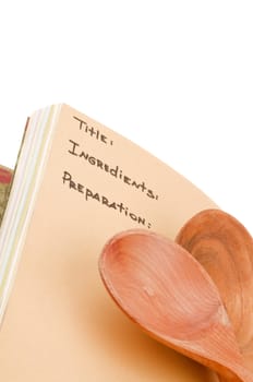 Wooden Spoons on Page of Cookbook with Named Sections closeup