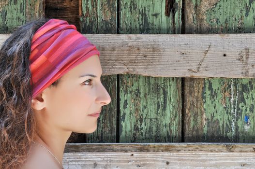 Beautiful woman stands in front of wooden wall