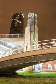 Nightview circular elevator and concrete spiral staircase in a city park
