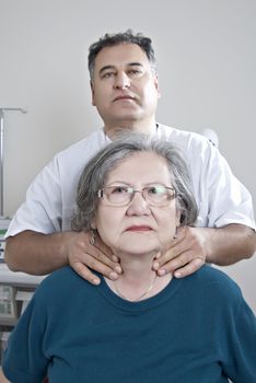 Doctor examing thyroid of mature patient