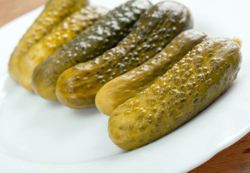 Gherkin pickles close up with washed away by back background
