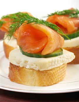    Canapes with smoked salmon,cheese and cucumber.  close up 