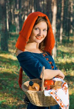 red Riding  hood standing in a wood . beautiful girl in medieval dress