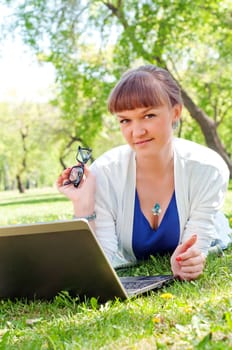 portrait of a beautiful woman, working with a laptop in a park