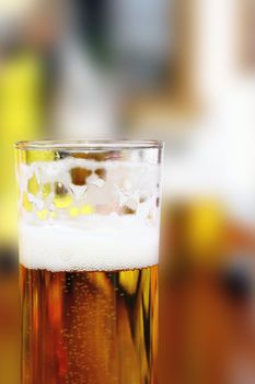 glass with beer over blurred background