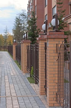 View of  beautiful fence, residential building and footpath, Russia.