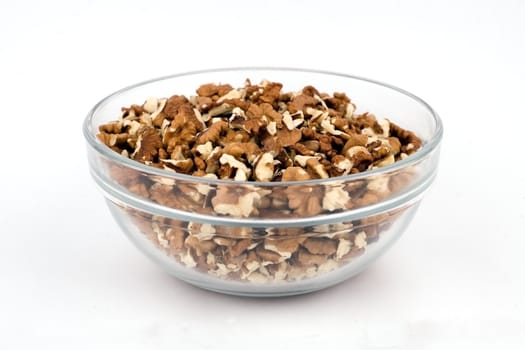 Walnuts close-up in a clear glass vase on a white background