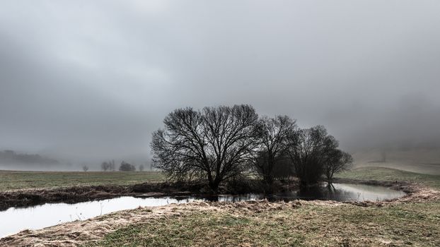 A river through Norwegian landscape in foggy weather