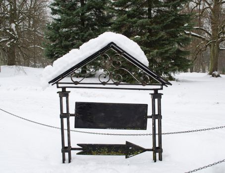 retro steel arrow show direction with blank board place for text covered with winter snow.
