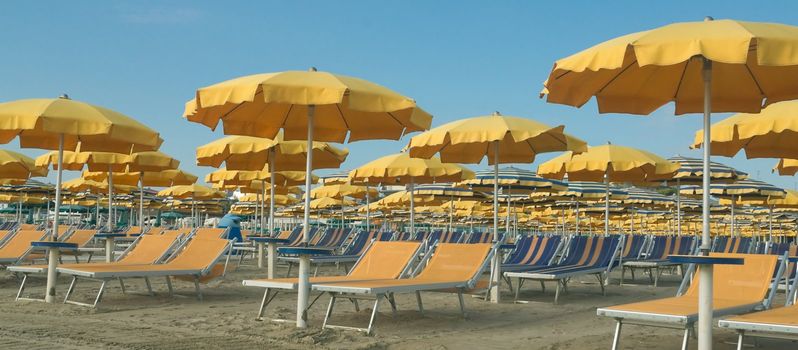 Umbrellas and sun beds on the beach in the glow of the setting sun