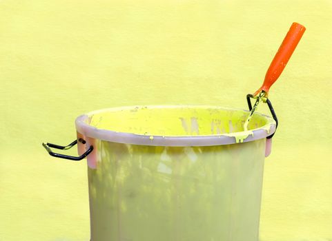 Paint-roller and Paint bucket with paint on a green background
