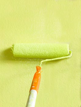 Wall painter using a paint roller, painting a wall in motion