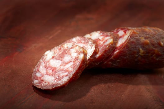 Sliced salami  on rustic wooden table, selective focus