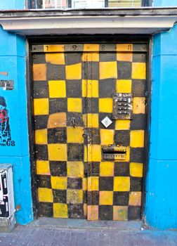 Black and yellow squares graffiti in doorway in Spuistraat, Amsterdam.