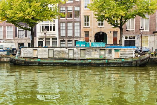 Ancient wooden houseboat closed in one canal of Amsterdam.