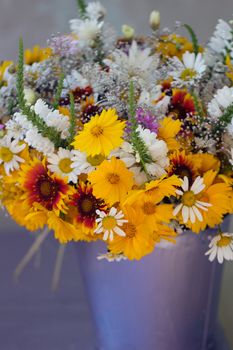 Beautiful bouquet of wild flowers in a purple bucket