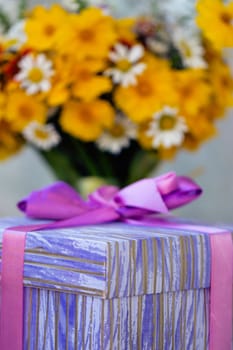 Bouquet of yellow wildflowers near the holiday gift