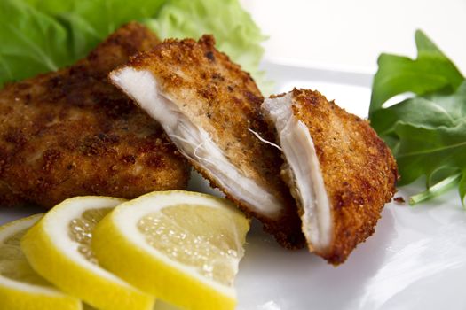 Breaded chicken breast with lemon and salad