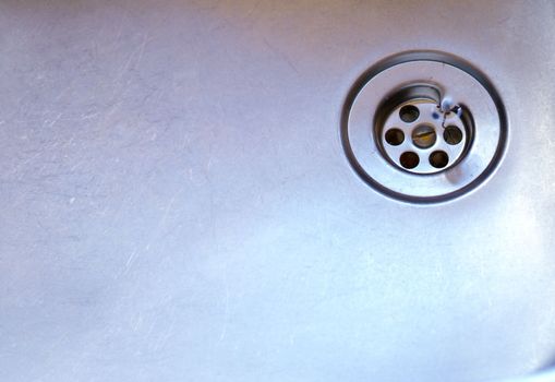 Water whirlpool flows out of clean kitchen sink down the drain