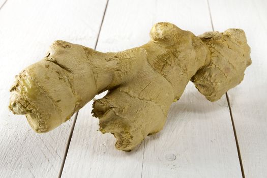 Fresh ginger on white wooden table